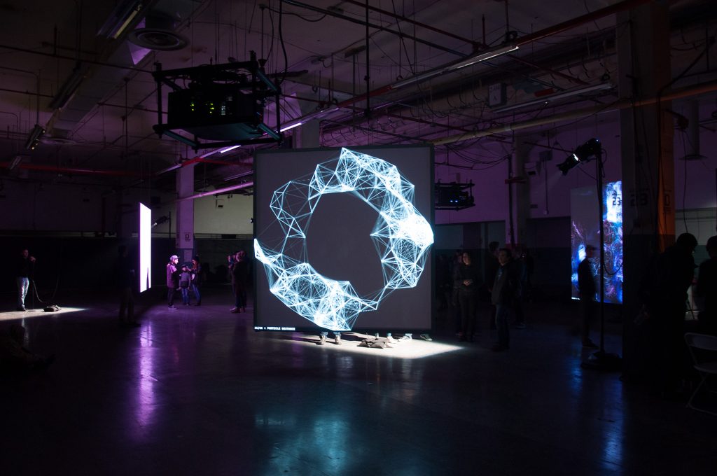 A large projection of a netlike structure on a screen in a dark room.